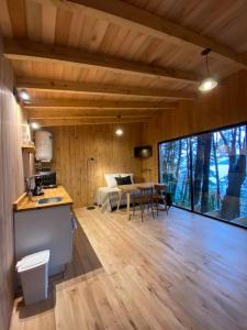 a room with a kitchen and a dining room with a table at Tiny house sobre el lago nahuel huapi in San Carlos de Bariloche