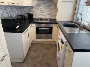 a kitchen with a stove and a sink at Marvellous Room 1 in Stoke on Trent +4 photos