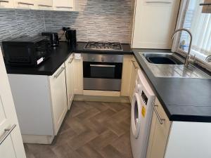 a kitchen with a stove top oven next to a sink at Marvellous Room 1 in Stoke on Trent