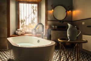 a bathroom with a tub and a vase on a table at Solar Madariaga Hotel in Vicuña