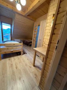 a room with a bed and a staircase in a cabin at Domki nad potokiem in Wetlina