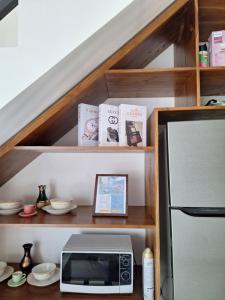 a kitchen with a counter with a microwave and books at Alzena villa batu in Batu +2 photos