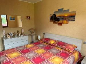a bedroom with a bed with a colorful comforter at Casa vacanze "INCANTO DEL LAGO" in Corna