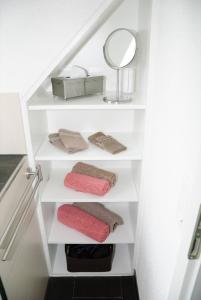 a staircase with white shelves with towels and a mirror at Ferienwohnungen Steiert in Freiburg im Breisgau