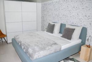 a bedroom with a blue bed with a brick wall at Ferienwohnungen Steiert in Freiburg im Breisgau