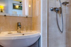 een badkamer met een wastafel en een douche bij Avenir Hotel Montmartre in Parijs