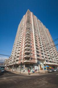 a large tall building with people in front of it at Icono central frente mall plaza 2 dormitorios in Antofagasta