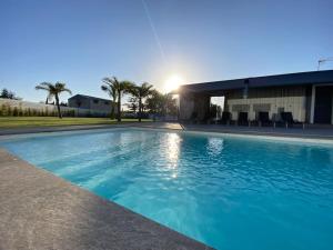 Una gran piscina azul frente a un edificio en Villa Romance, en Chipiona