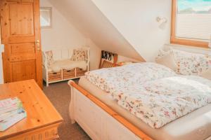 a bedroom with a bed and a table and a chair at Kaminhaus 2 Fehmarn mit Sauna und Kamin in Fehmarn