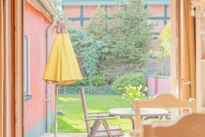 a patio with a table and a yellow umbrella at Kaminhaus 2 Fehmarn mit Sauna und Kamin in Fehmarn