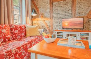 a living room with a couch and a bowl of fruit on a table at Kaminhaus 2 Fehmarn mit Sauna und Kamin in Fehmarn
