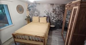 a bedroom with a bed and a wall mural at Maison neuve jardin & terrasse in Lanton