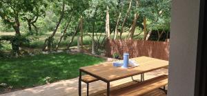 a wooden table with a blue candle on top of it at Maison neuve jardin & terrasse in Lanton