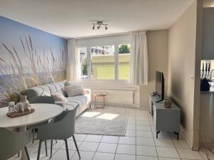 a living room with a couch and a table at Ferienwohnung SUN SAND SEA in Horn