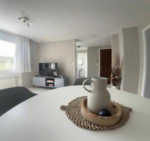 a white vase sitting on a table in a bedroom at Ferienwohnung SUN SAND SEA in Horn