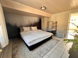 a bedroom with a large bed with a black headboard at Ferienwohnung SUN SAND SEA in Horn