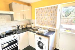 a kitchen with a sink and a washing machine at Cozy 3-Bed House Near Willen Lake with Garden in Milton Keynes