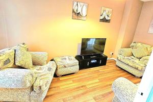 a living room with two couches and a flat screen tv at Cozy 3-Bed House Near Willen Lake with Garden in Milton Keynes