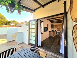 a patio with a table and chairs and a kitchen at Hampton Collection Avenues - Urban 4 Sleeper Serviced Apartment in Durban
