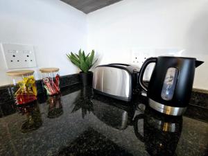 a kitchen counter with a toaster and a coffee maker at Hampton Collection Avenues - Urban 4 Sleeper Serviced Apartment in Durban