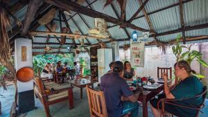 a group of people sitting at a table in a restaurant at Mwana House in Nungwi