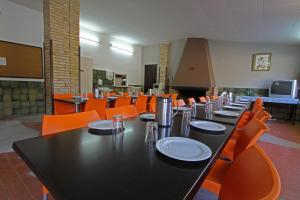 a dining room with a black table and orange chairs at El Xalió in Sant Miquel de Campmajor