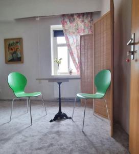 two green chairs and a table in a room at Nr 5 Doppelzimmer mit Talblick in Annaberg-Buchholz +9 photos