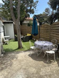 a table and chairs and an umbrella in a yard at Maison 47m2 à 800 m de la plage in Saint-Raphaël