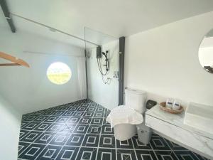 a bathroom with a toilet and a sink and a window at Pak Himdoi Farm Homestay สวนผักฮิมดอยโฮมสเตย์ ฝาง in Ban Wiang Kok