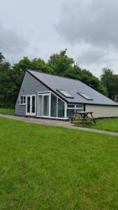 un edificio con una mesa de picnic frente a un campo en 8 The Coombe, en Kilkhampton