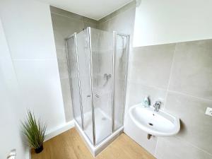a white bathroom with a shower and a sink at I Apartment 14 Personen - Monteurzimmer - Ferienwohnung, Großköllnbach I in Pilsting