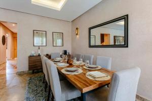 a dining room with a table with chairs and a mirror at Villa Atlas Harmony Marrakech in Marrakech