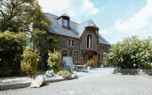 a large brick house with a roof at Altes Kelterhaus & Plein Hotel by Markus Plein in Wintrich