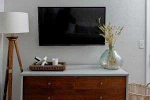 a tv sitting on top of a dresser with a vase at Quiet, convenient & Modern Haven in Gainesville