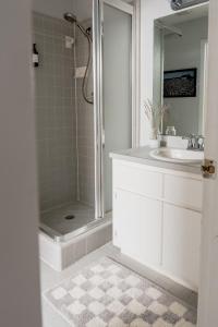 a white bathroom with a shower and a sink at Quiet, convenient & Modern Haven in Gainesville