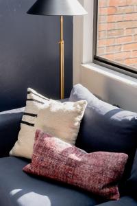 a blue couch with pillows on it with a lamp at Quiet, convenient & Modern Haven in Gainesville