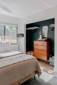 a bedroom with a bed and a dresser and a mirror at Quiet, convenient & Modern Haven in Gainesville