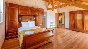 a bedroom with a large bed and wooden furniture at Villa Panoramique - Lac du Bourget in Bourdeau