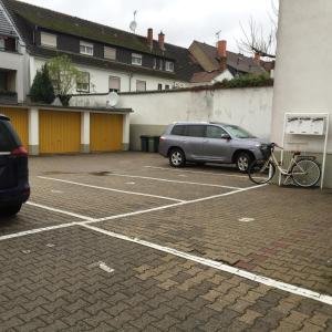 samochód zaparkowany na parkingu obok budynku w obiekcie MyRooms w mieście Neu-Isenburg