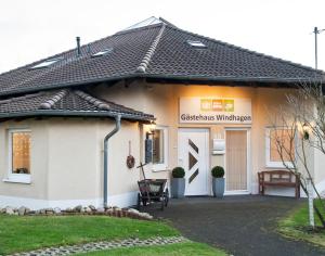 een wit huis met een teken dat de kerstwildernis leest bij Gästehaus Windhagen in Windhagen