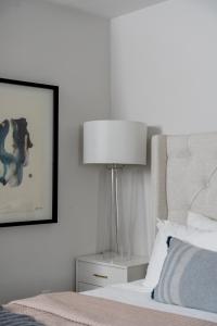 a bedroom with a bed and a lamp on a night stand at Quiet, convenient & Modern Haven in Gainesville