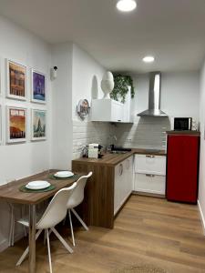 a kitchen with a table and a red refrigerator at La Casa de la Abuela in Jaén