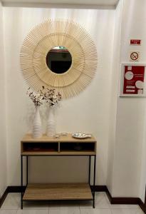 a mirror on a wall next to a table at Apartamento F.A in Pedrógão