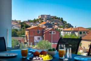 a plate of fruit on a table with a view at Providenca Residence Šibenik in Šibenik