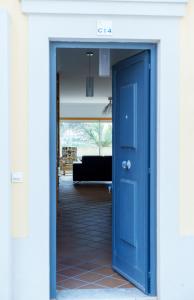 a blue door leading into a living room with a couch at T3 terraço e piscina Praia del Rey Óbidos C14 in Amoreira