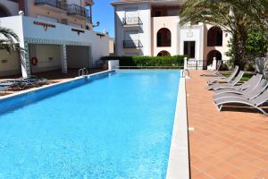 a swimming pool with lounge chairs next to a building at T3 terraço e piscina Praia del Rey Óbidos C14 in Amoreira
