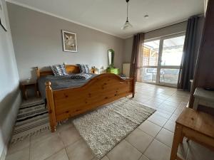 a bedroom with a large wooden bed with a rug at Hörselberg Apartment in Hörselberg-Hainich