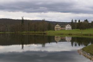 a large house sitting on the side of a lake at Hörselberg Apartment in Hörselberg-Hainich