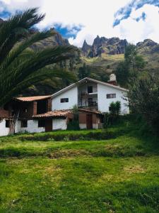 una casa blanca en un campo con montañas en el fondo en Casa de montaña - Fundo Vilcar, en San Salvador 6 fotos más