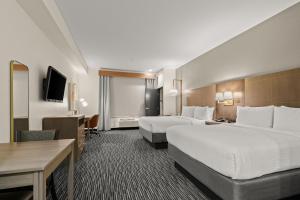 a hotel room with two beds and a desk at Holiday Inn Gonzales by IHG in Gonzales +25 photos